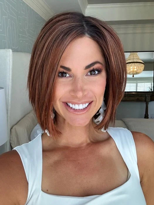 Smiling woman wearing short brown bob wig for women with layered ends and natural center part in living room
