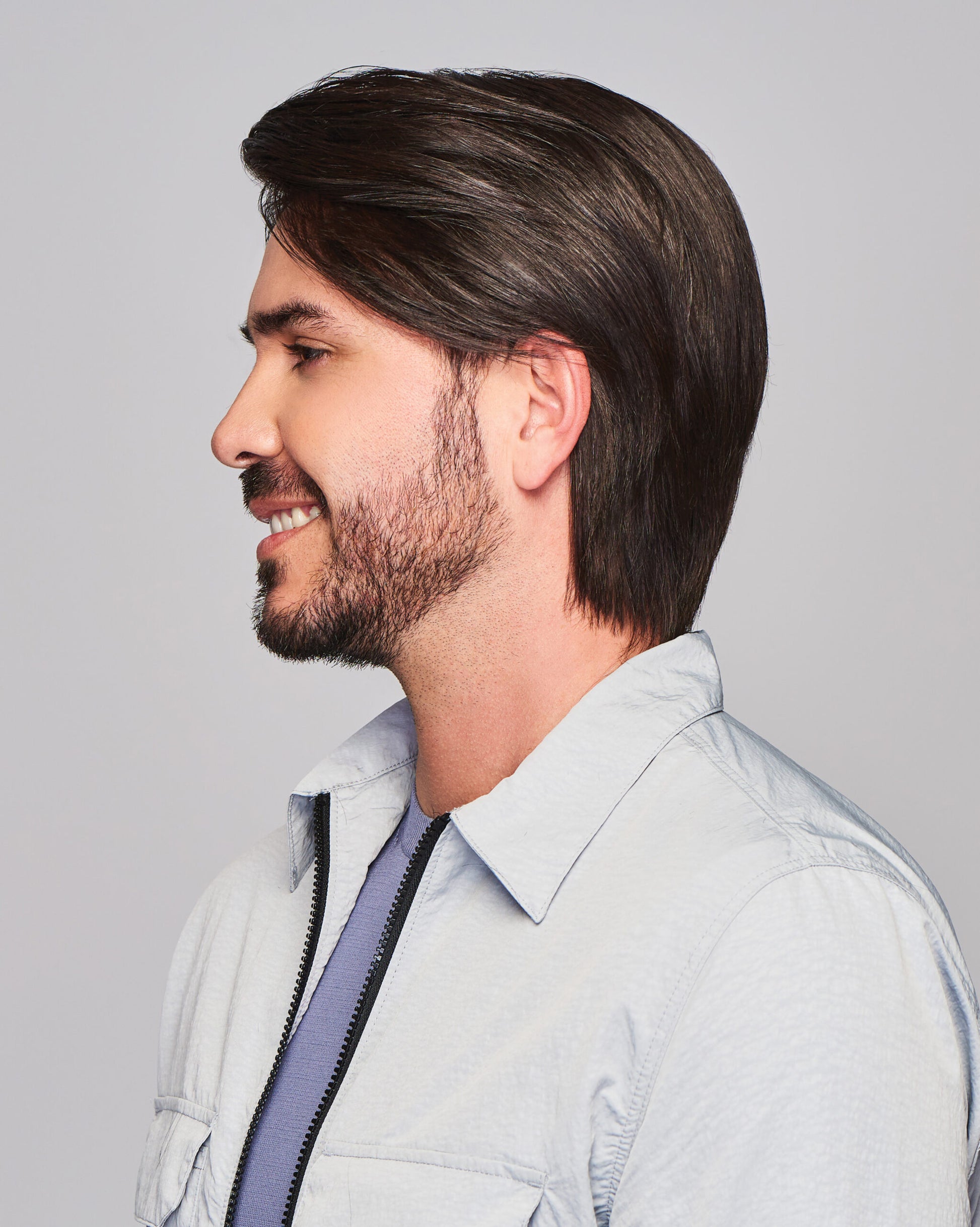 Sharp HIM wig for men on a smiling male model in profile dark brown medium length natural hairline