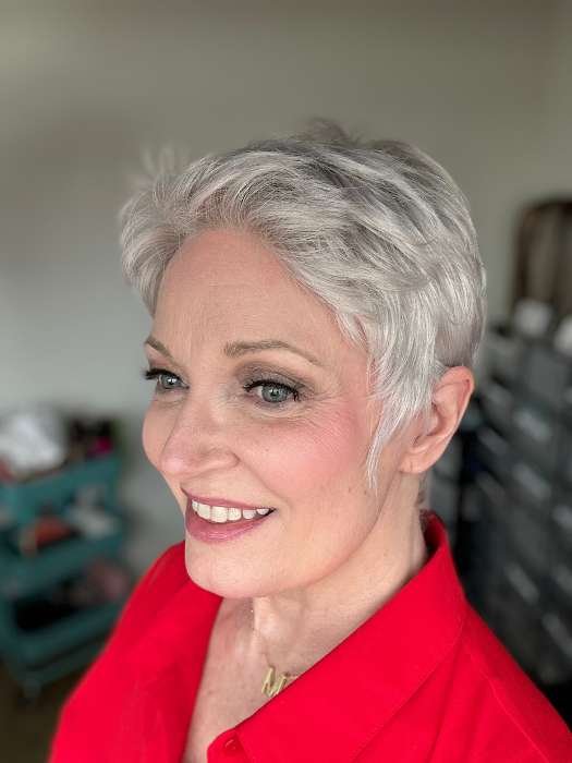 Mature woman smiling wearing silver pixie hairstyle Ellen Wille Risk wig in a red blouse side profile